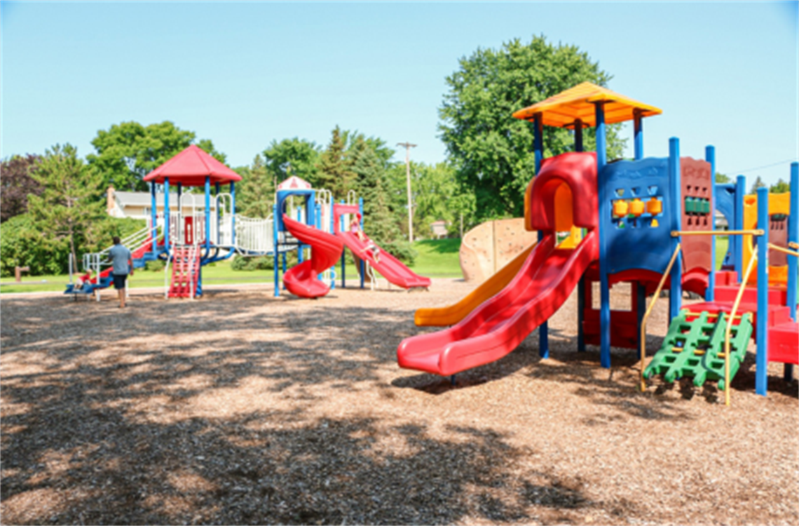 Two small playground structures with slides and climbing features