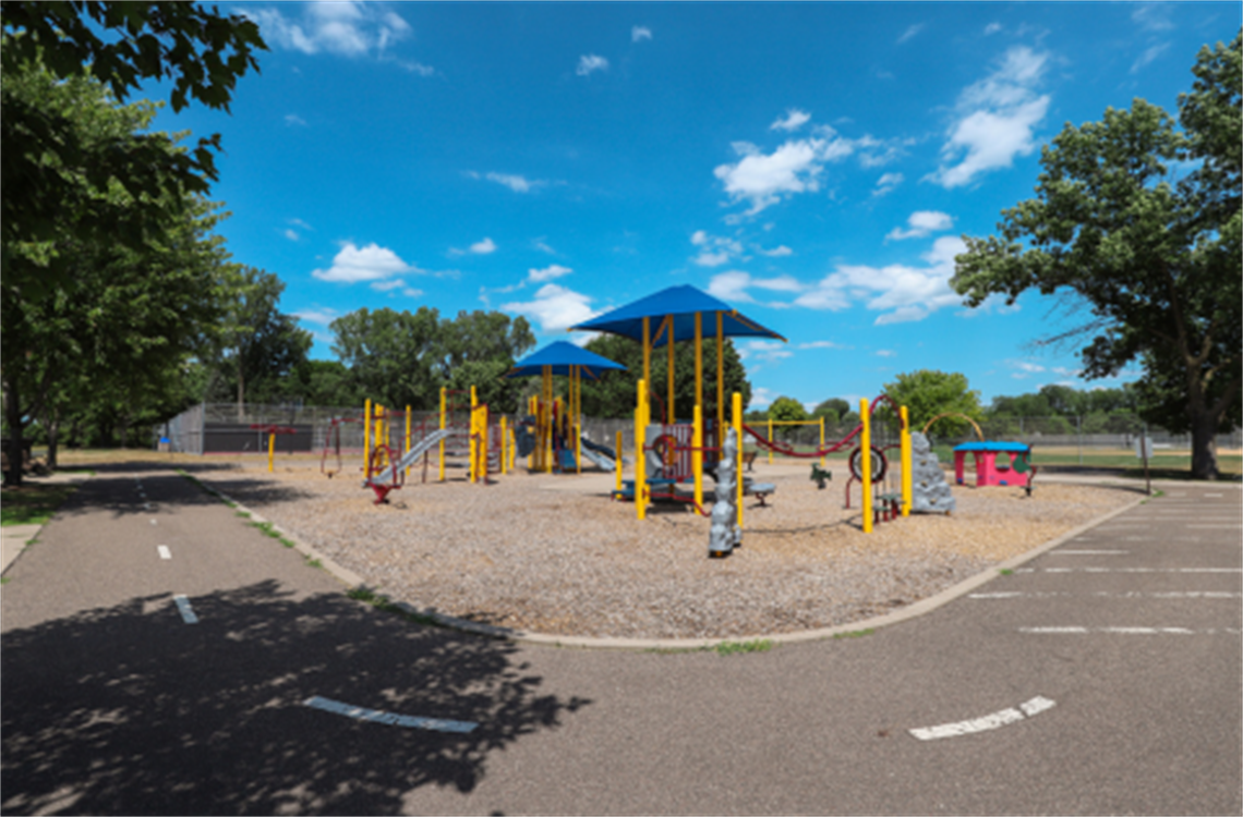 A blue and yellow playground structure is surrounded by a circular track